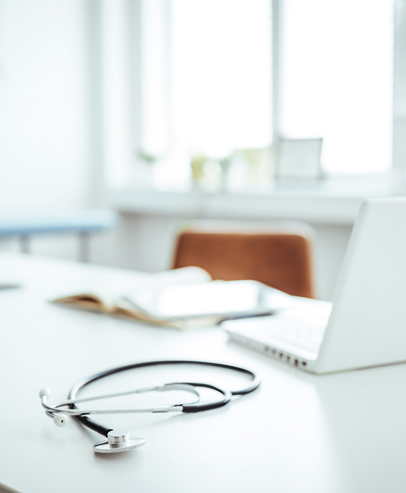 Medizinisches Bürointerieur mit Computer, Untersuchungstisch. Stethoskop